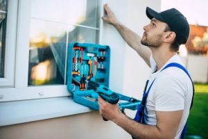 worker checking window work with tools in hand